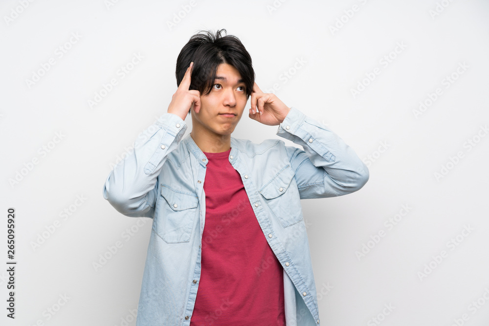 Asian man on isolated white background having doubts and thinking Asian man on isolated white background having doubts and thinking