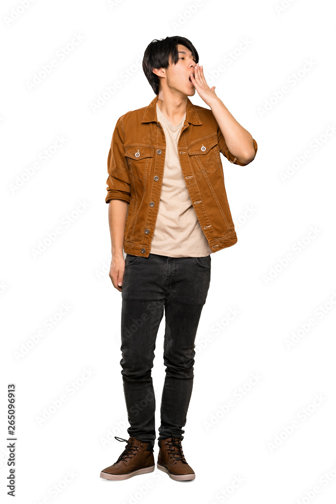 A full-length shot of a Asian man with brown jacket yawning and covering wide open mouth with hand over isolated white background A full-length shot of a Asian man with brown jacket yawning and covering wide open mouth with hand over isolated white background