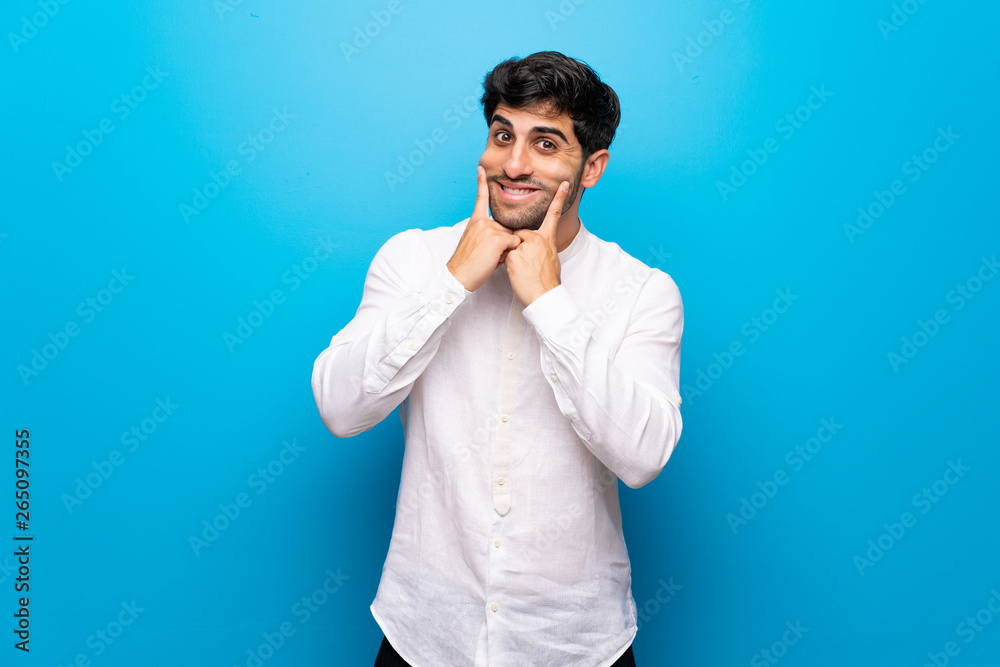 Young man over isolated blue wall smiling with a happy and pleasant expression Young man over isolated blue wall smiling with a happy and pleasant expression