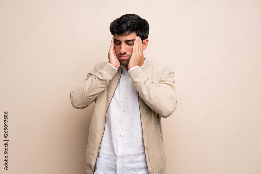 Young man over isolated wall with headache Young man over isolated wall with headache