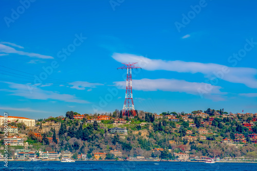 High voltage power lines on a hill  . Electrical tower over residential buildings in Istanbul, Turkey 