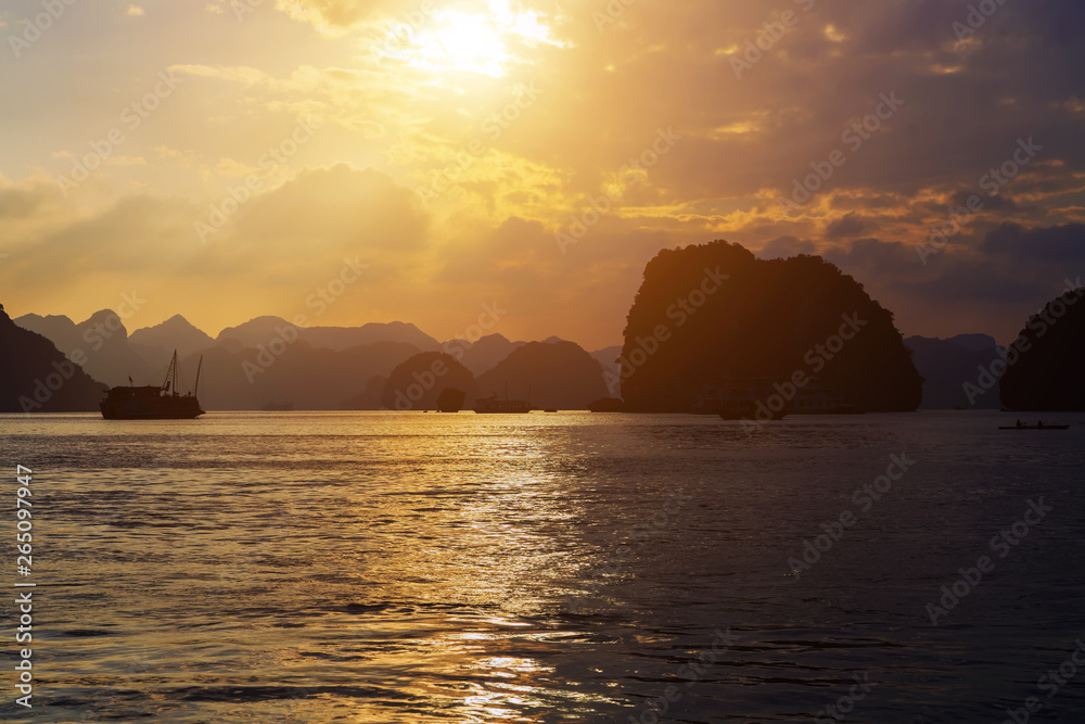 Cruise is a traditional wooden junk sailing rock islands Sunset Background. Vietnam Top Destinations, Ha Long Bay