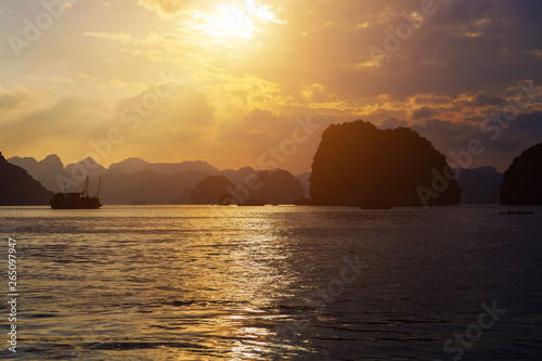 Cruise is a traditional wooden junk sailing rock islands Sunset Background. Vietnam Top Destinations  Ha Long Bay