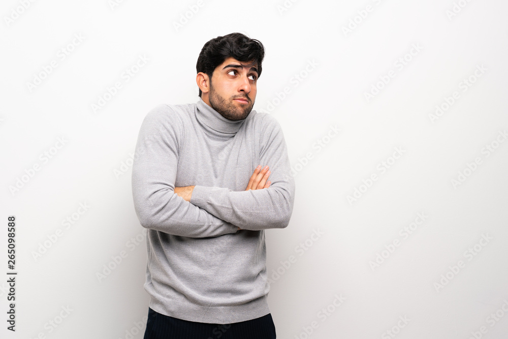 Young man over isolated white wall making doubts gesture looking side Young man over isolated white wall making doubts gesture looking side