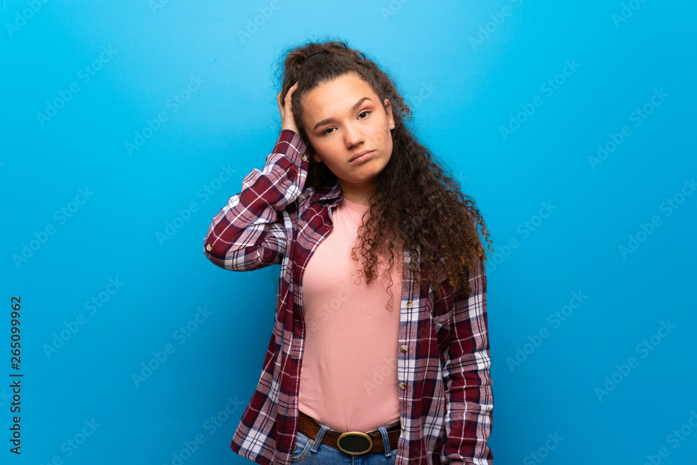 Teenager girl over blue wall with an expression of frustration and not understanding Teenager girl over blue wall with an expression of frustration and not understanding
