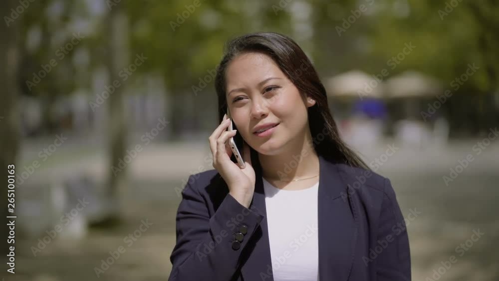 Attractive girl talking by cell phone outdoor. Beautiful smiling young woman standing on street and having phone conversation. Communication concept Attractive girl talking by cell phone outdoor. Beautiful smiling young woman standing on street and having phone conversation. Communication concept