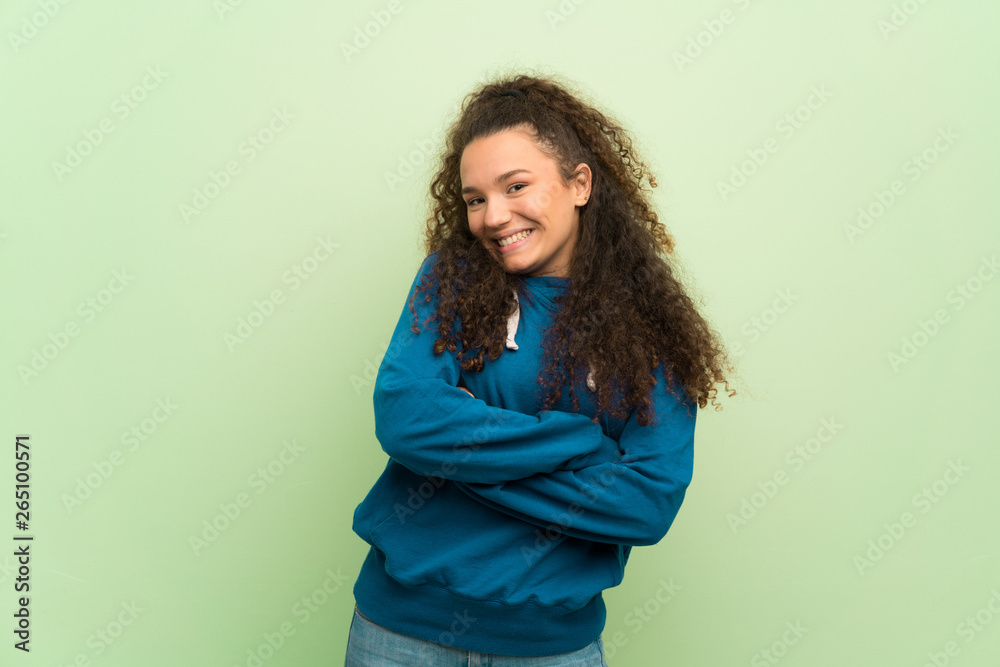 Happy Teenager girl over green wall. Happy Teenager girl over green wall.