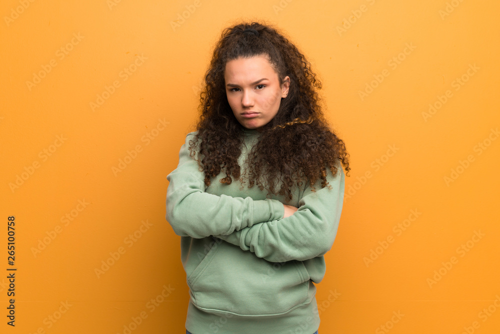 Teenager girl over ocher wall feeling upset Teenager girl over ocher wall feeling upset
