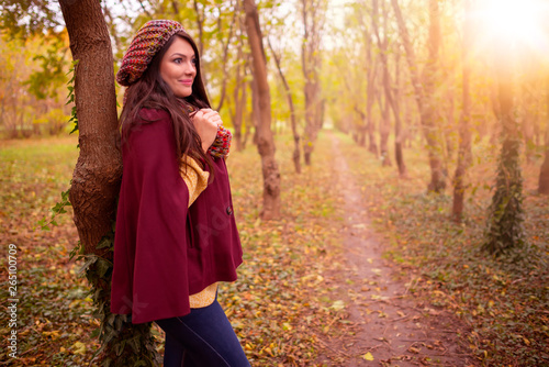 Beautiful girl in stylish fall fashion clothes in park scenery, in nice warm autumn sunlight. Gorgeous romantic young woman outdoors. American plan shot in natural light, retouched, vibrant colors