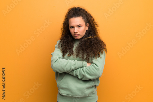 Teenager girl over ocher wall feeling upset © luismolinero