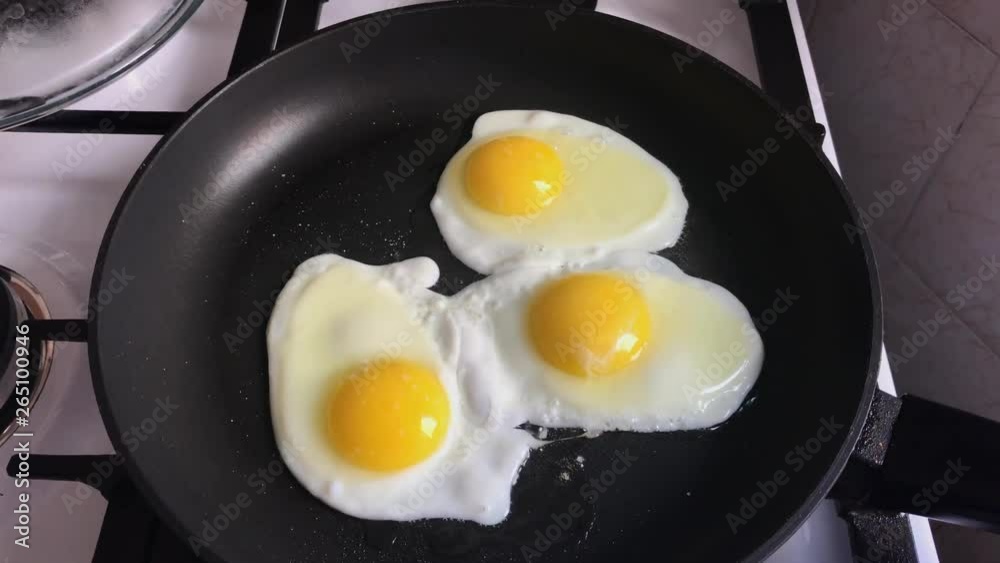 Three organic chicken eggs being fried on iron skillet. Three organic chicken eggs being fried on iron skillet.