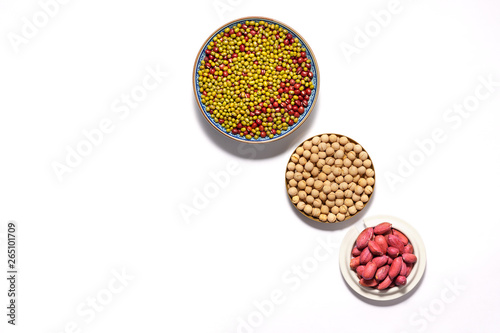 Dry peanuts and variety of beans in plate isolated on white background