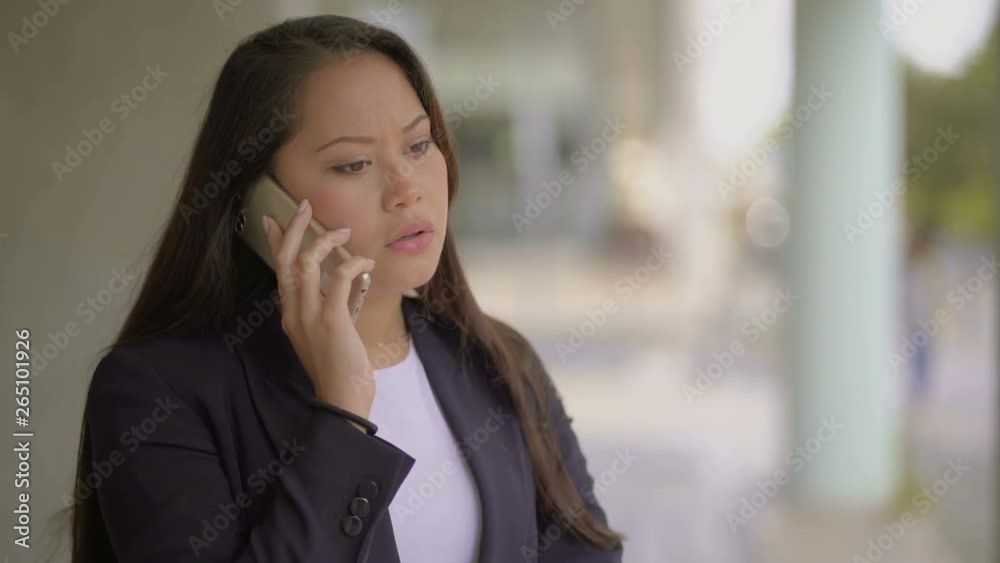 Upset woman talking by mobile phone. Stressed nervous young woman standing on street and having unpleasant phone talk. Communication concept Upset woman talking by mobile phone. Stressed nervous young woman standing on street and having unpleasant phone talk. Communication concept
