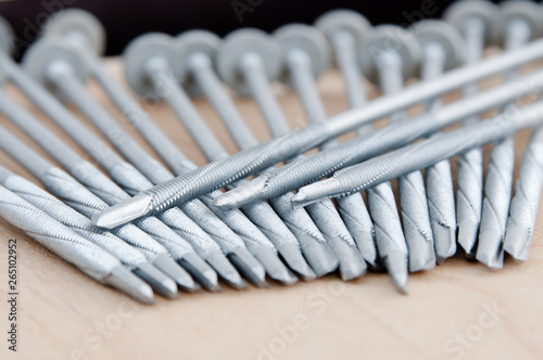 Screws photo background. Metal screws are used to fasten insulation panels to the metal frame of a new building.
