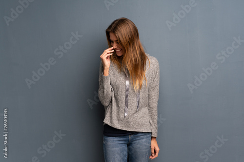 Blonde woman over grey background Happy and smiling