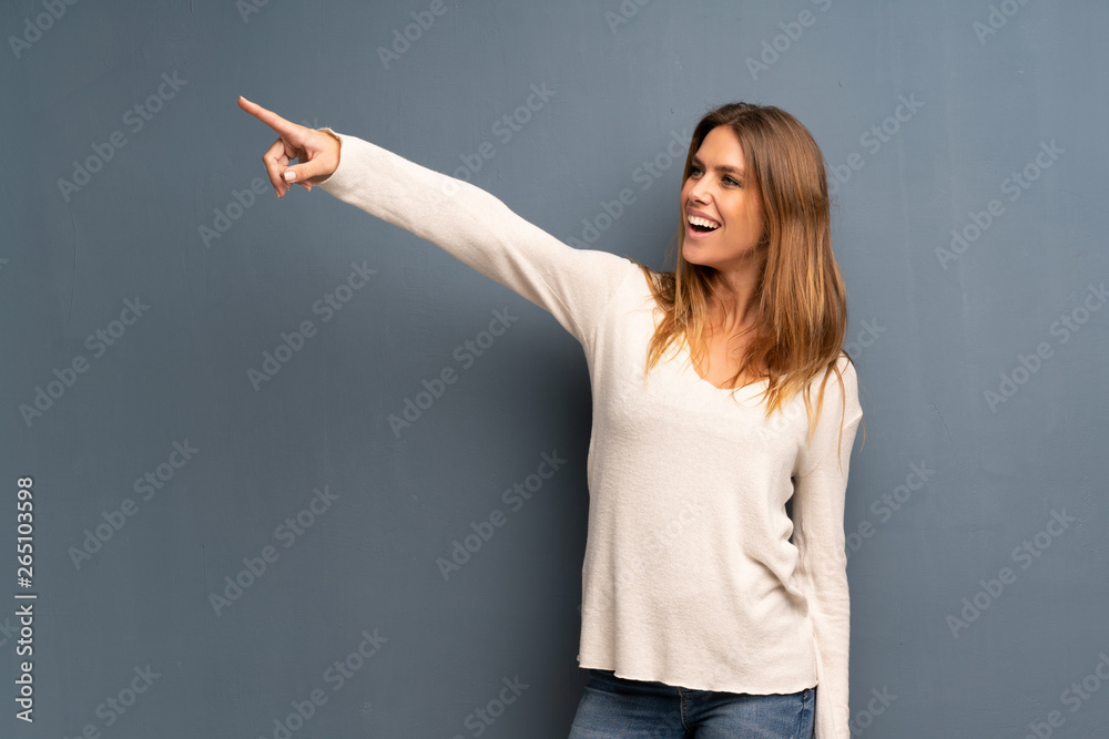 Blonde woman over grey background pointing away Blonde woman over grey background pointing away