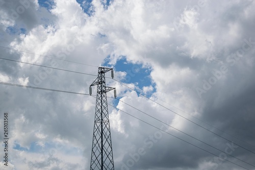 Electric power pole in the cloudy sky