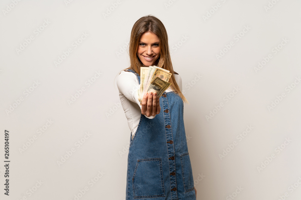 Beautiful woman over isolated white wall taking a lot of money Beautiful woman over isolated white wall taking a lot of money