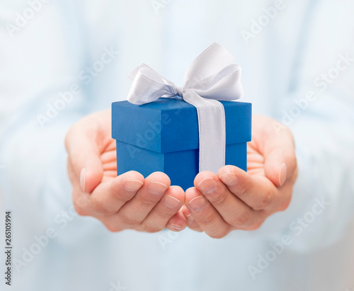 Naklejka Small blue present box in hands 