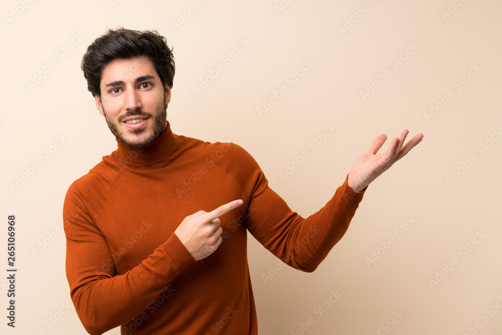 Handsome over isolated wall extending hands to the side for inviting to come Handsome over isolated wall extending hands to the side for inviting to come