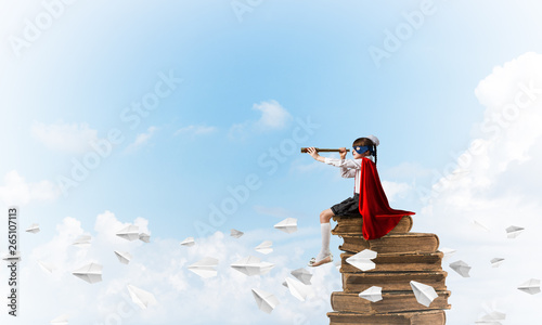 Girl power concept with cute kid guardian against cloudscape background