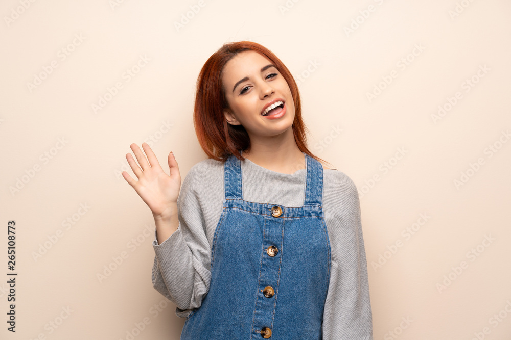 Young redhead woman over isolated background saluting with hand with happy expression Young redhead woman over isolated background saluting with hand with happy expression