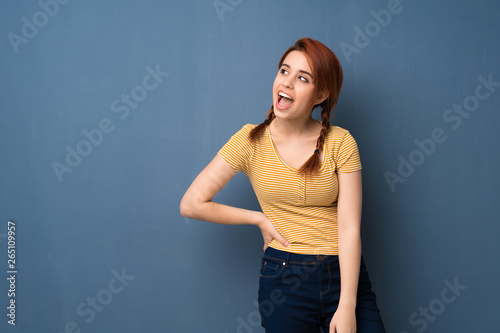 Young redhead woman over blue background smiling