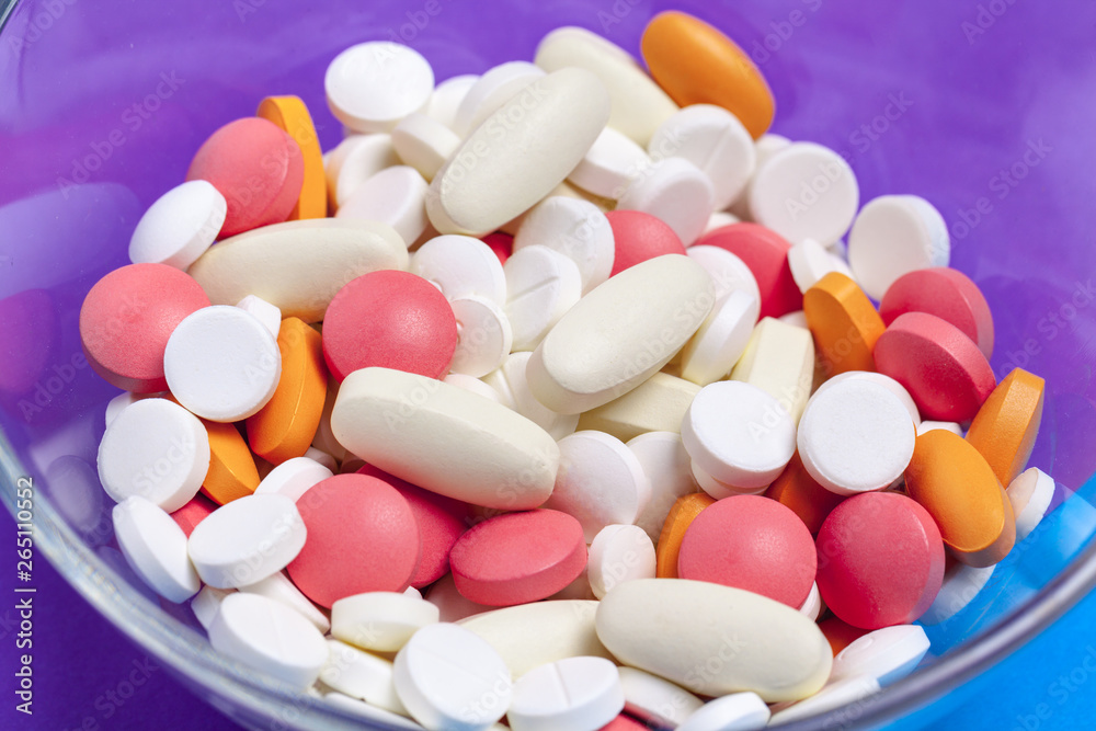 set of multi-colored tablets and capsules on a blue background set of multi-colored tablets and capsules on a blue background