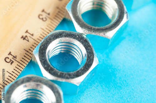 Blue industry or construction abstract background with various nuts on  blue surface photo