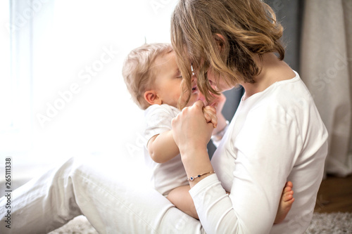 Beautiful mother and little son 9 months in the home interior. Cozy. Baby. Motherhood.