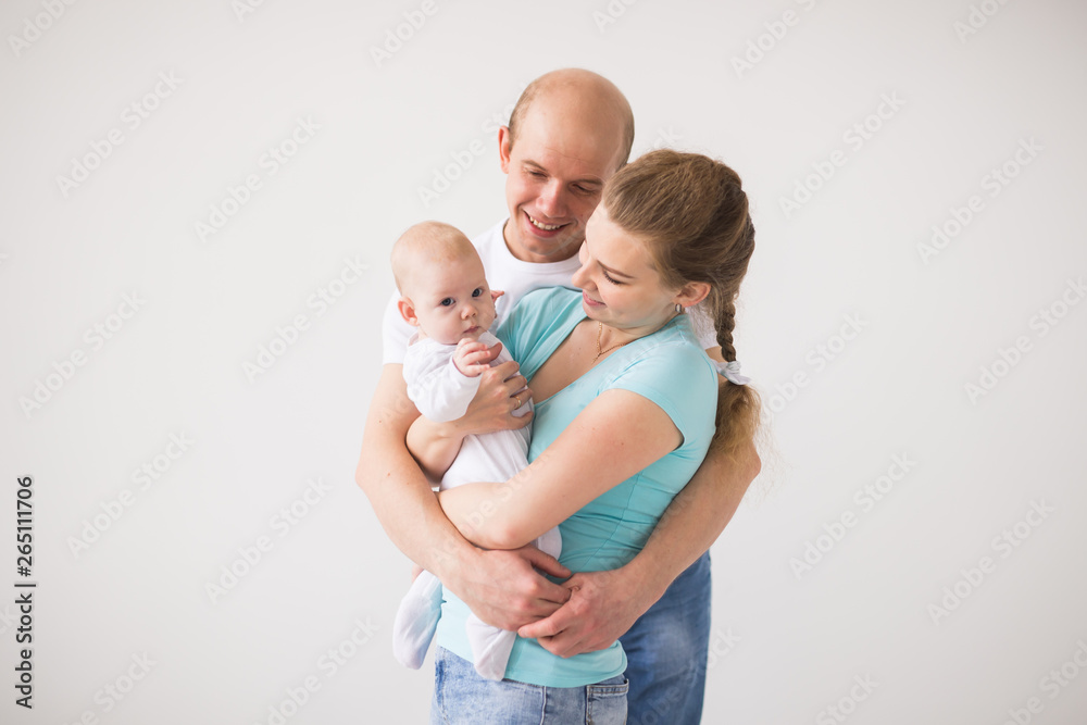 Family, parent and children concept - Portrait of a happy family with their baby daughter on white background Family, parent and children concept - Portrait of a happy family with their baby daughter on white background