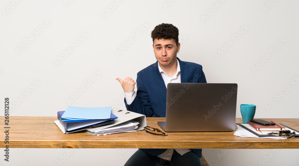 Business man in a office unhappy and pointing to the side Business man in a office unhappy and pointing to the side