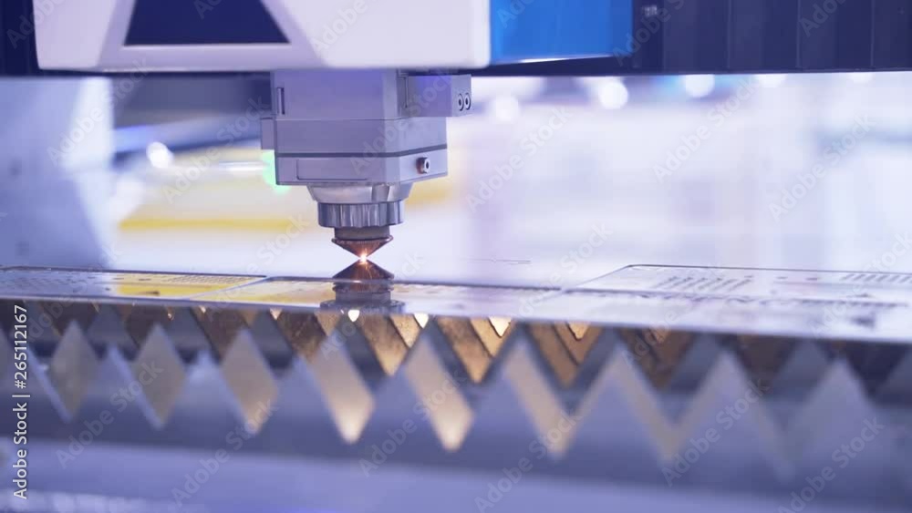 Machining and cutting of metallic part close up. Computer control of high tech manufacture of construction product. Accuracy of iron working. Close up. Hot flame from motion of ray. Bright sparks. Machining and cutting of metallic part close up. Computer control of high tech manufacture of construction product. Accuracy of iron working. Close up. Hot flame from motion of ray. Bright sparks.