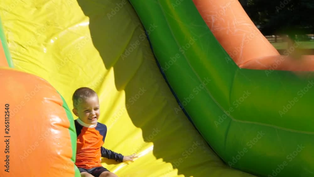 Slow motion of the kids on a water slide on a hot summer day