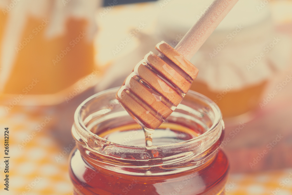 Honey background. Sweet honey in glass jar on wooden background. Honey background. Sweet honey in glass jar on wooden background.