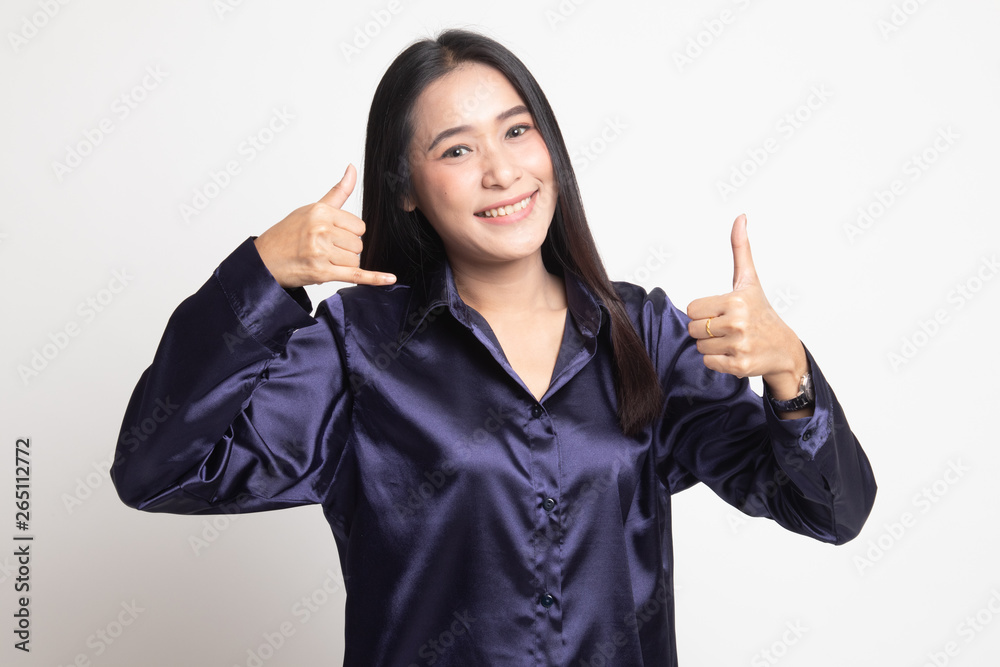 Young Asian woman thumbs up show with phone gesture. Young Asian woman thumbs up show with phone gesture.