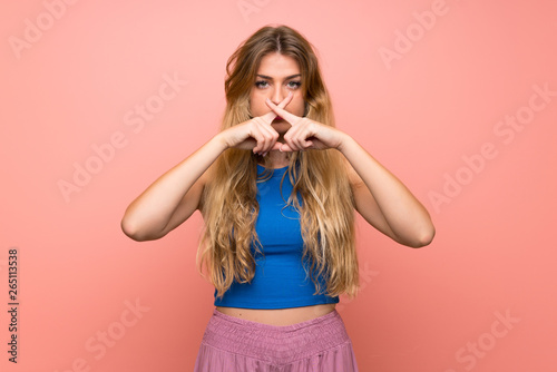 Young blonde woman over isolated pink background showing a sign of silence gesture