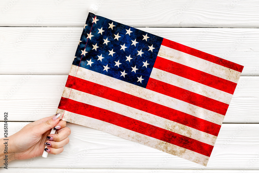 Obraz premium Memoral day of United States of America with flag in hand on white wooden background top view