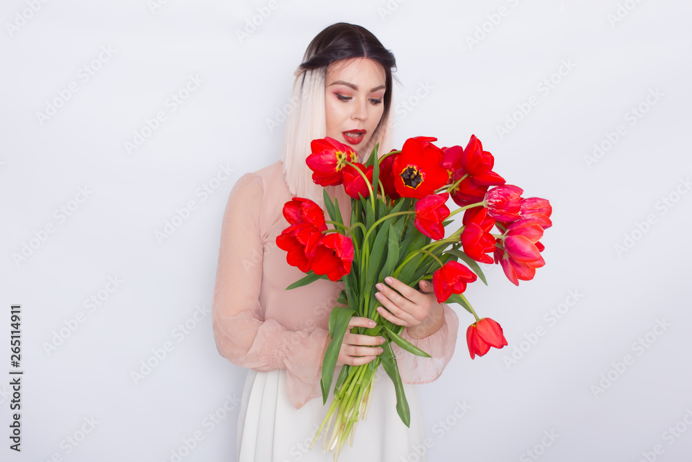Beautiful blonde woman with red tulips on Womans or Mothers Day Beautiful blonde woman with red tulips on Womans or Mothers Day