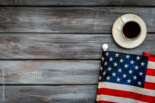 Independence day of USA with flag and cup of coffee on gray wooden background top view space for text photo