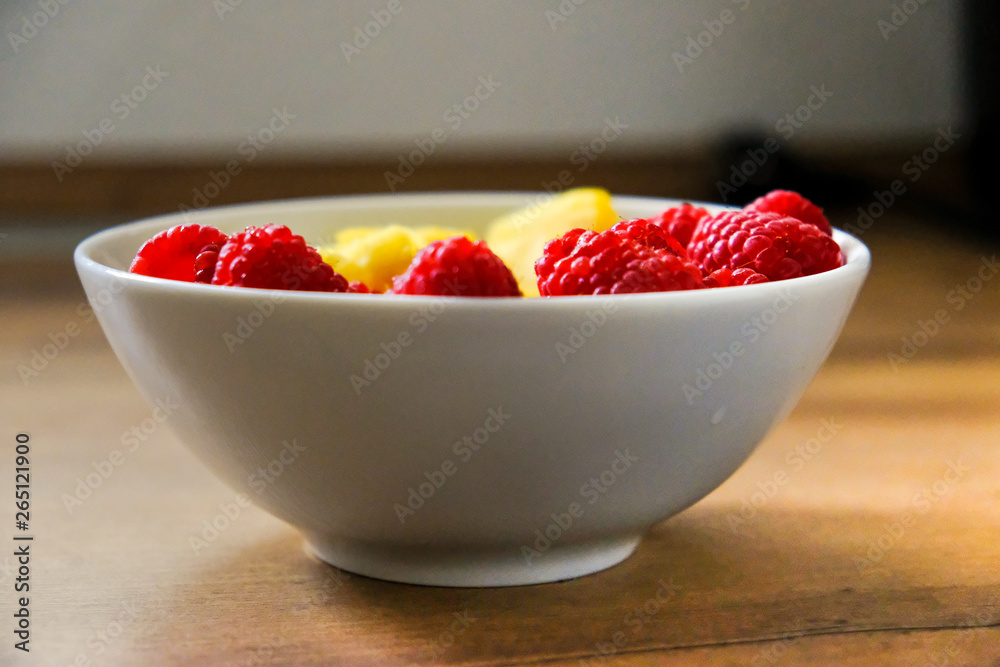 Ananasstücke und Himbeeren in einer Schale Ananasstücke und Himbeeren in einer Schale