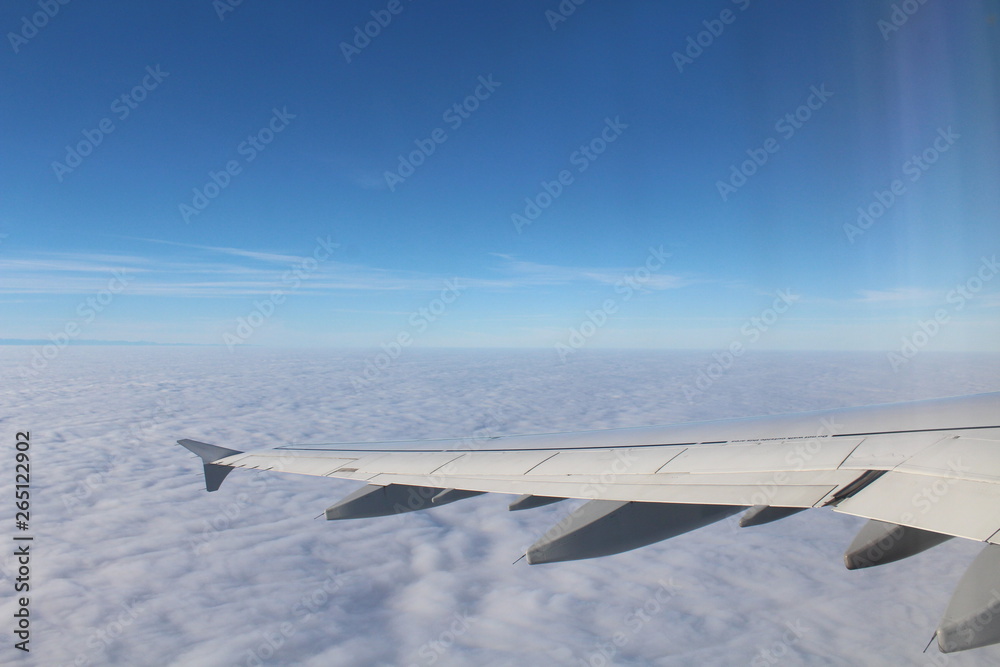 Fototapeta premium Flügel von einem Verkehrsflugzeug über den Wolken