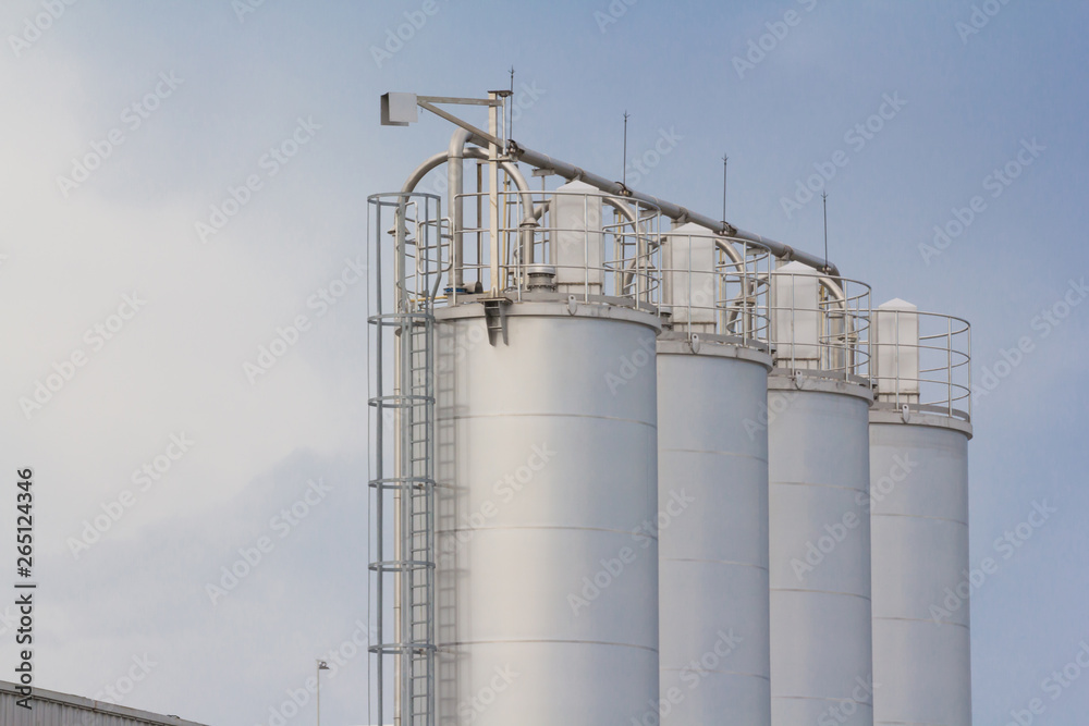 industry stainless steel silos. metal container with steel cage ladder.