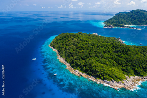 Aerial drone view of boats around the shallow coral reef surrounding beautiful tropical islands (Similan Islands)