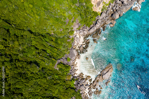 Aerial view of a small bay on a beautiful tropical island with coral reef and granite boulders