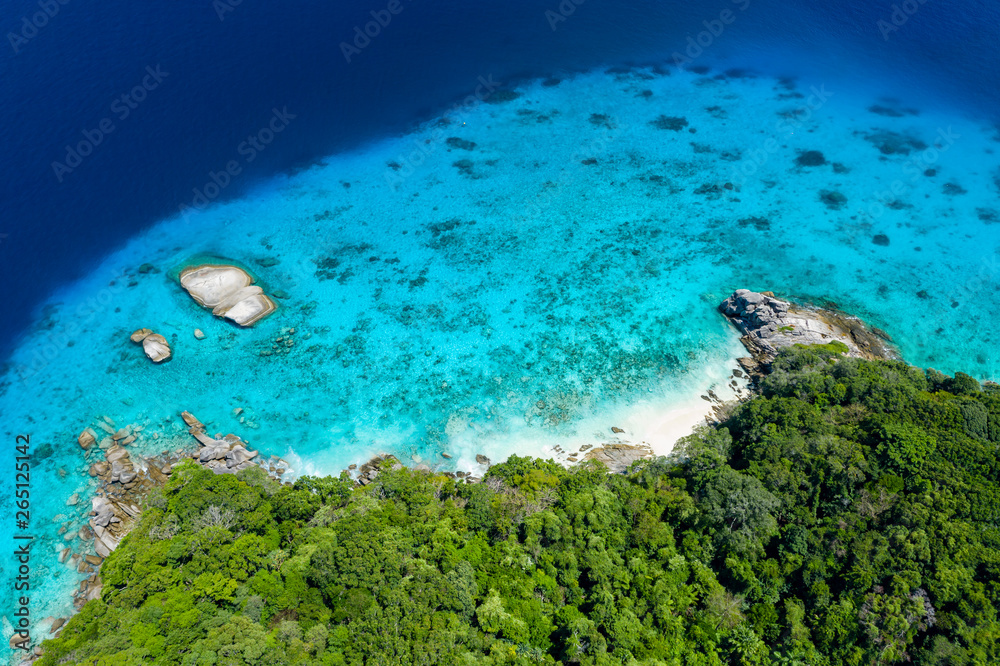 Aerial drone view of boats and coral reef around beautiful tropical islands in a warm ocean