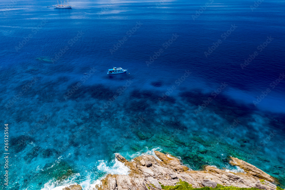 Aerial drone view of boats and coral reef around beautiful tropical islands in a warm ocean
