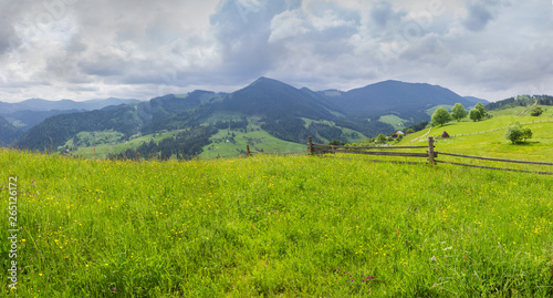 Mountain ranges with fenced hayfields on a foreground