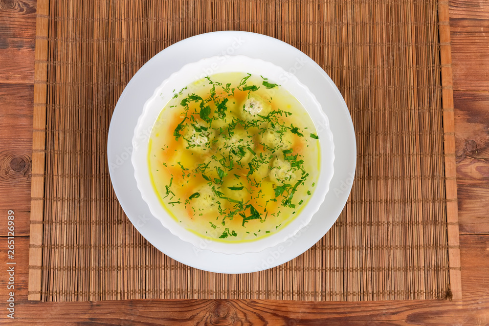 Top view of chicken meatballs soup in the white dish Top view of chicken meatballs soup in the white dish