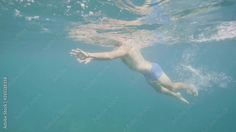 Unrecognizable man is swimming, underwater shot. Unrecognizable man is swimming, underwater shot.